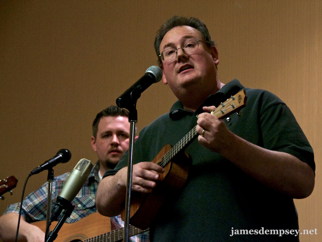 James Dempsey playing ukulele and singing and Ben Scheirman playing the guitar