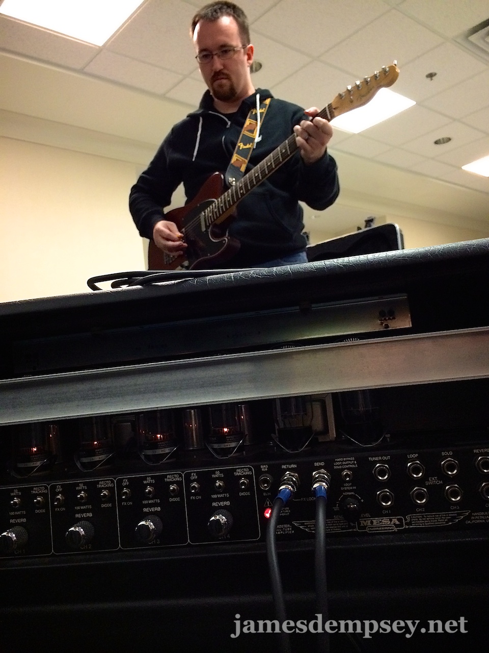Brandon Alexander playing electric guitar in front of a big amplifier