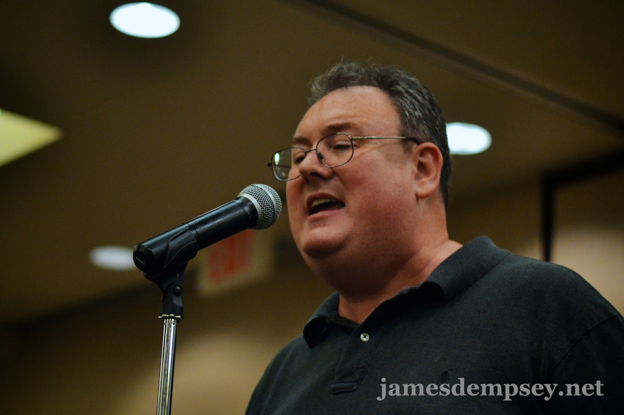 James Dempsey singing at a microphone