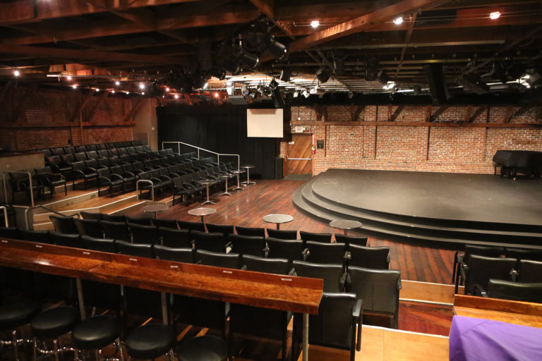 Interior of The Tabard Theater showing tiered seating around a quarter-circle shaped stage
