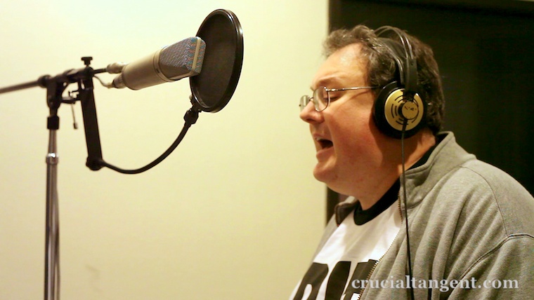 James Dempsey singing into a microphone in the studio