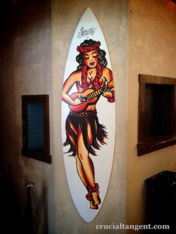 A surfboard with a picture of a hula dancer painted on it