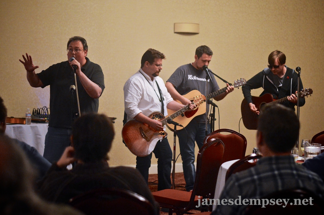 James Dempsey sings while Daniel Pasco, Ben Scheirman and Jonathan Penn play guitar for the Breakpoint Jam at CocoaConf Boston 2013