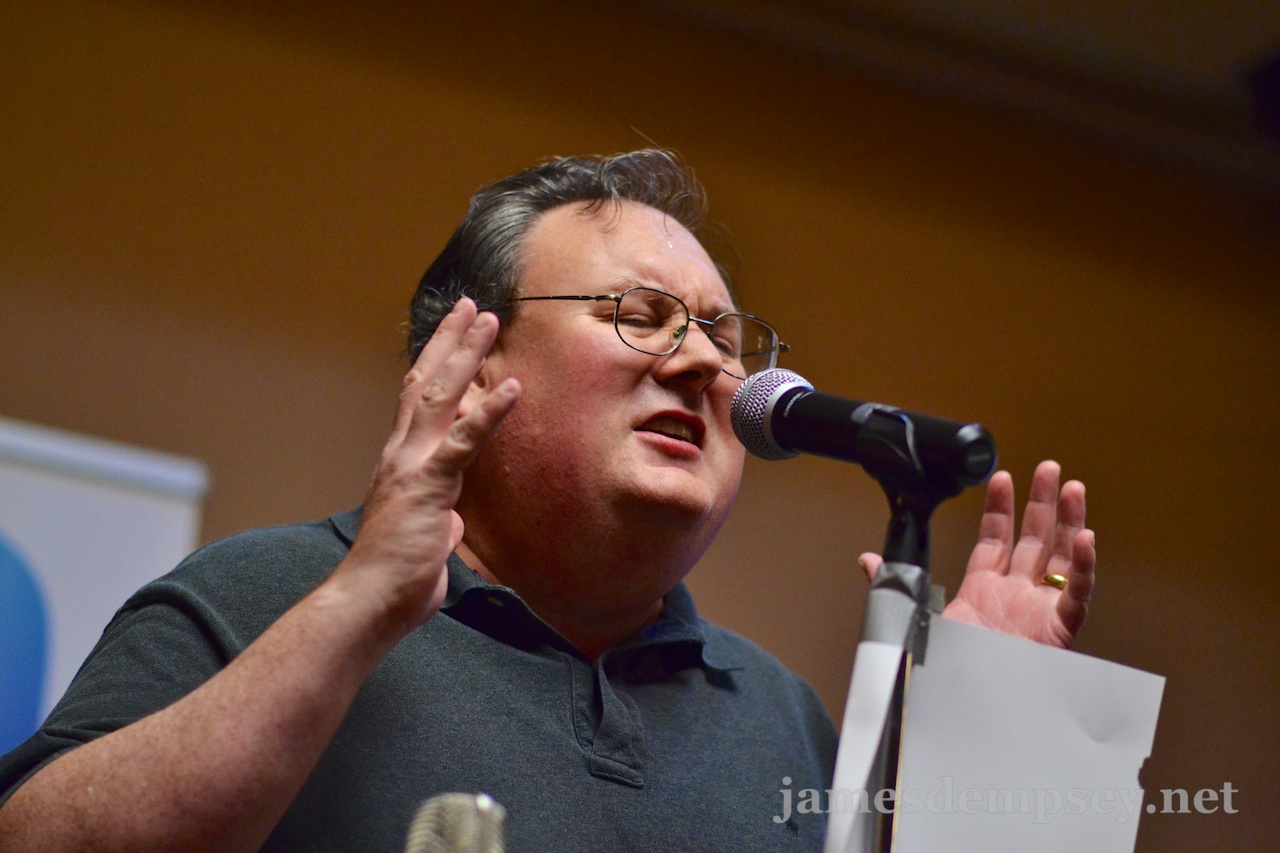 James Dempsey singing at a microphone
