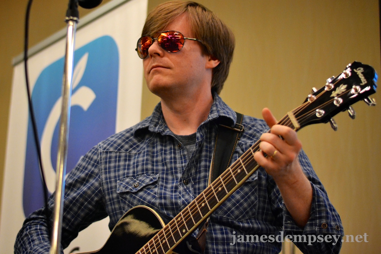 Jonathan Penn in mirrored sunglasses playing guitar