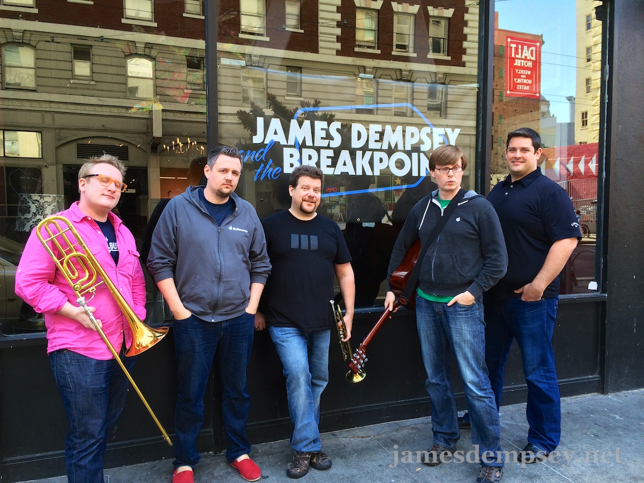 Sam Davies, Ben Scheirman, Daniel Pasco, Jonathan Penn and Nathan Eror stand outside the venue in front of a James Dempsey and the Breakpoints banner