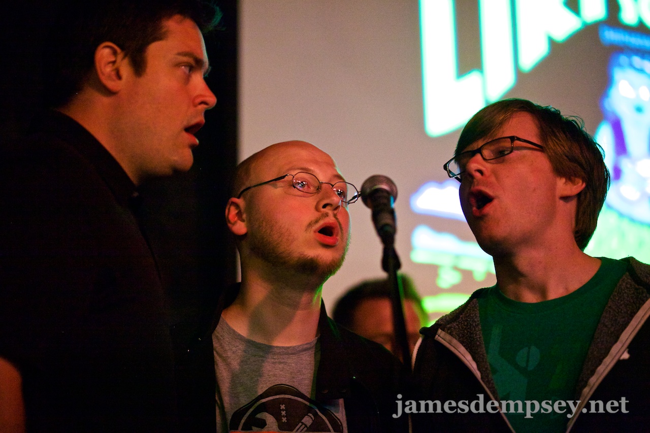 Nathan Eror, Uli Kusterer and Jonathan Penn gathered around a microphone singing The Liki Song